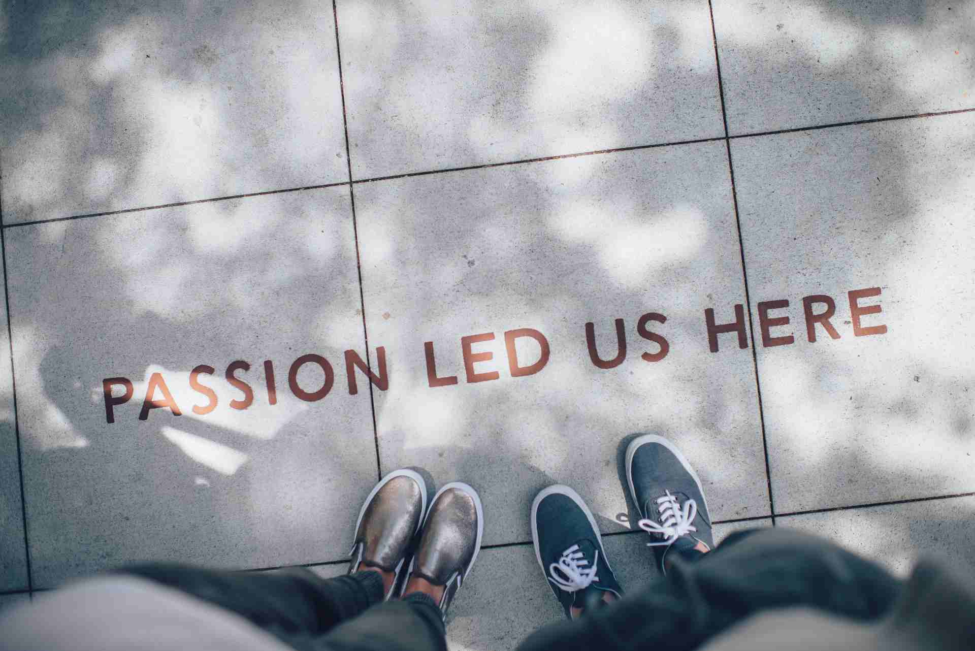 passion led us here letras sobre acera pies pareja