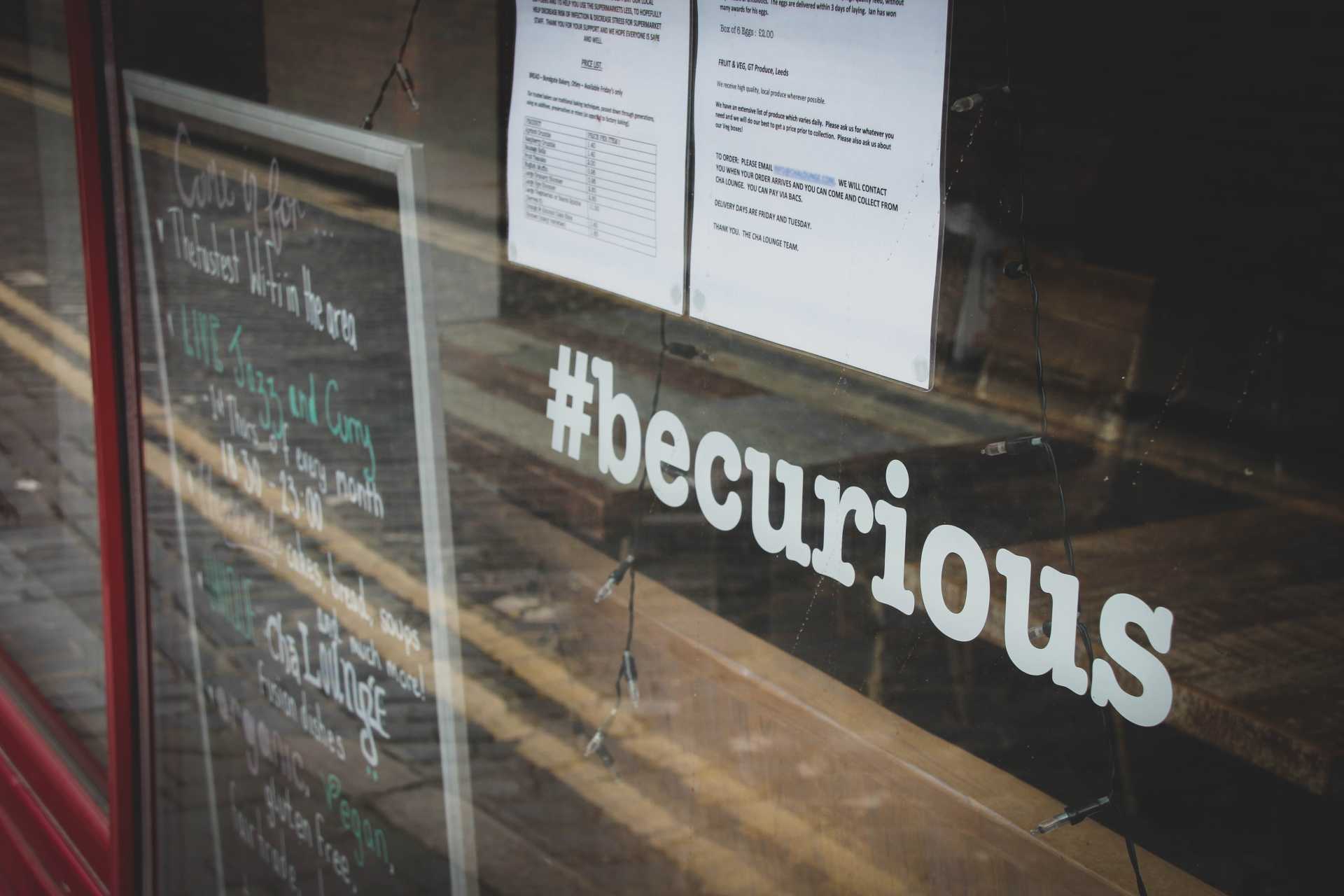 escaparate con mensaje be curious en cristal para hablar de los tipos de curiosidad